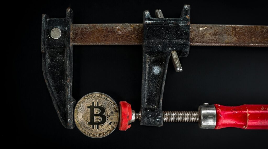 Conceptual image of cryptocurrency represented by a Bitcoin secured in a rusty clamp.