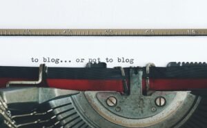 Classic typewriter with 'to blog or not to blog' typed on paper.